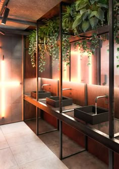 a bathroom with two sinks and plants on the wall