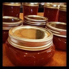 several jars filled with honey sitting on top of a wooden table