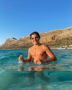 a man swimming in the ocean with no shirt on