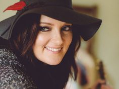 a woman wearing a black hat and smiling