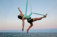 a woman doing aerial acrobatics on the beach