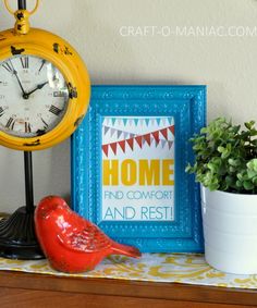 a yellow clock sitting on top of a wooden table next to a potted plant