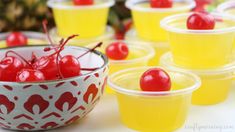 small plastic cups filled with cherries on top of a table