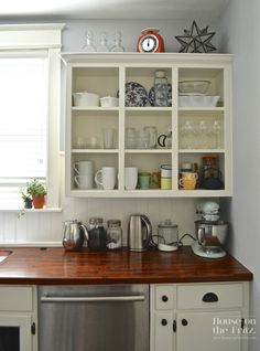 a kitchen with white cabinets and wooden counter tops