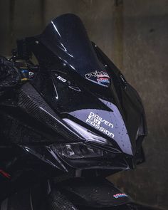 a close up view of the front end of a black motorcycle with shiny paint on it