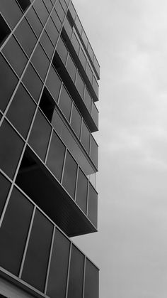 a black and white photo of the side of a tall building with lots of windows