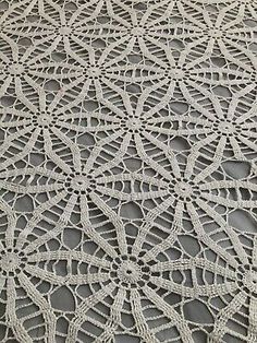 an intricate crocheted tablecloth with white thread