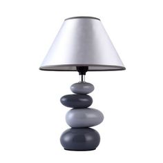 a lamp that is sitting on top of some rocks in front of a white background