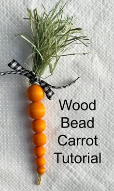 an orange carrot tied with a black ribbon on top of a white sheet that says wood bead carrot - tutor