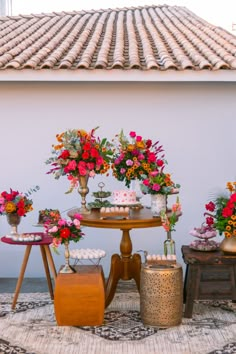 a table topped with cakes and flowers on top of a rug