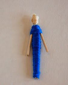 a blue doll hanging on the wall next to it's head and legs,