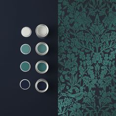 the wallpaper is dark green and has several different shades of paint on it, including blue