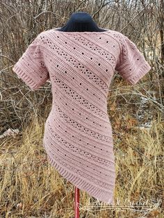 a pink knitted sweater sitting on top of a mannequin's head