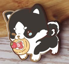 a black and white dog with a strawberry in its mouth sticker on a wooden surface