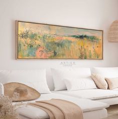 a living room with white furniture and a painting on the wall above it that says arteier canvass