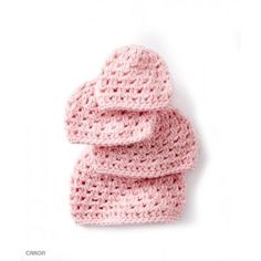 three pink crocheted hats are stacked on top of each other in the shape of hearts