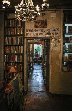 the inside of a book store with many books on shelves and a chandelier hanging from the ceiling