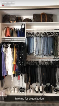 a closet filled with lots of clothes and handbags on top of white shelving