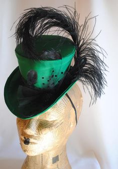 This seductive evening mini top hat is an excellent choice for any dark cabaret event. It is covered with a rich emerald green(pictured) or black thick satin fabric and embellished with various black trimmings. A curled black ostrich feather, dotted black tulle, chic black stripped rooster feathers and a glorious black beaded button. For sparkling burlesque style appearances! Measurements : height 4 inches( 10 cm ) front to back 9 inches ( 22 cm ) side to side 7.5 inches ( 19 cm ) This mini top Fitted Halloween Evening Hats, Fitted Hats For Halloween Evening, Green Fitted Hat Band For Kentucky Derby, Fitted Green Hat Band For Kentucky Derby, Fitted Green Hat Bands For Kentucky Derby, Curved Brim Top Hat For Kentucky Derby Costume, Fitted High Crown Hat For Carnival, Fitted High Crown Costume Hat For Carnival, Gatsby Mini Hat For Kentucky Derby