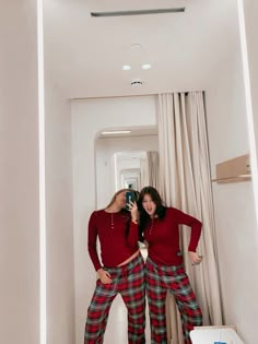 two women in red shirts and plaid pants taking a selfie