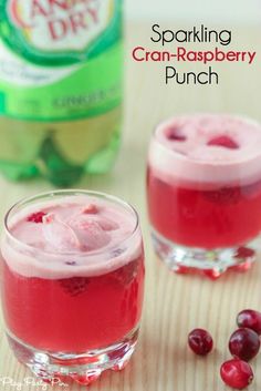 two glasses filled with cran - raspberry punch on top of a wooden table