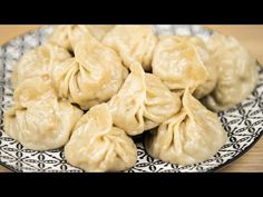 some dumplings are sitting on a black and white plate