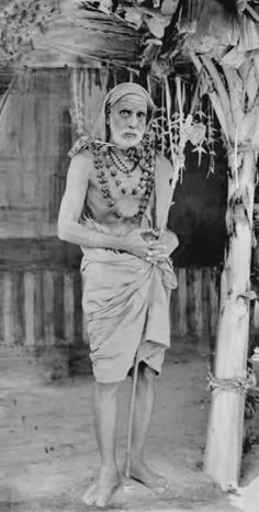 an old black and white photo of a man in native garb