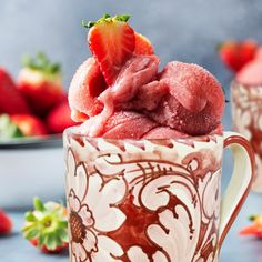 a strawberry souffle in a mug with strawberries on the side