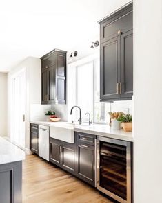 a kitchen with black cabinets and white counter tops