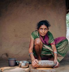 a woman kneeling down next to a stone slab