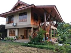 a large house with lots of windows on the front and side of it, surrounded by greenery