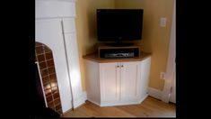 a flat screen tv sitting on top of a white cabinet