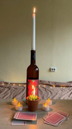 a bottle with candles and cards on a table