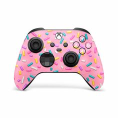 a pink game controller with sprinkles and circles on the front, it has two