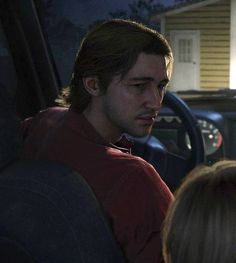 a man sitting in the back seat of a car next to a blonde haired woman