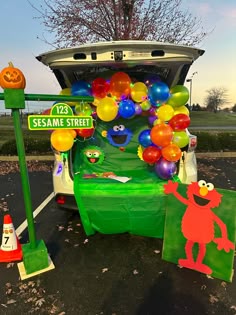 the sesame street car is decorated with balloons and decorations for halloween time, as well as an elm street sign