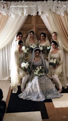 a bride and her bridal party posing for a photo in front of the wedding arch