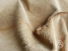 a close up view of a tan colored fabric with some fur on the top and bottom