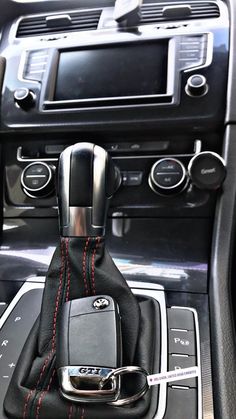 the interior of a car with an automatic gear lever and phone holder in it's center console