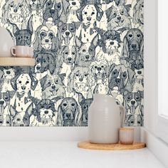 a wall with many dogs on it and a vase in the foreground next to them