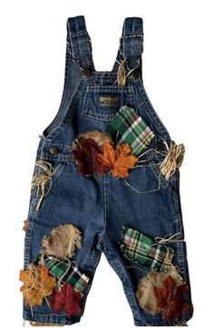 a pair of jeans with fall leaves and plaid bows on the front, hanging from a clothes line