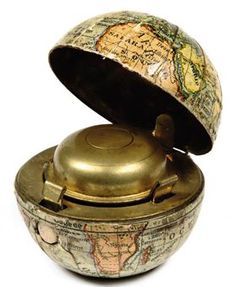 an old brass globe with a lid on it's side and a map in the middle