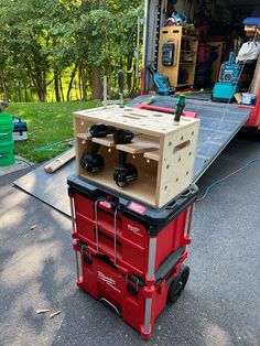 a red tool box sitting on the back of a moving truck with tools in it