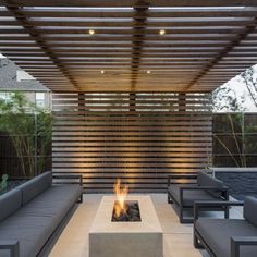 an outdoor living area with couches and fire pit