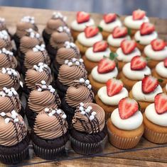 cupcakes and strawberries are arranged on a table