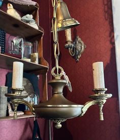 a chandelier hanging from the ceiling in a room with red walls and shelves