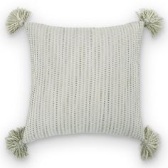 a white pillow with two tassels on it