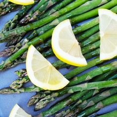 asparagus and lemon slices on a blue plate