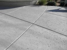 a skateboarder doing a trick in the air on a concrete surface near a house