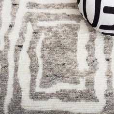 a black and white pillow sitting on top of a rug